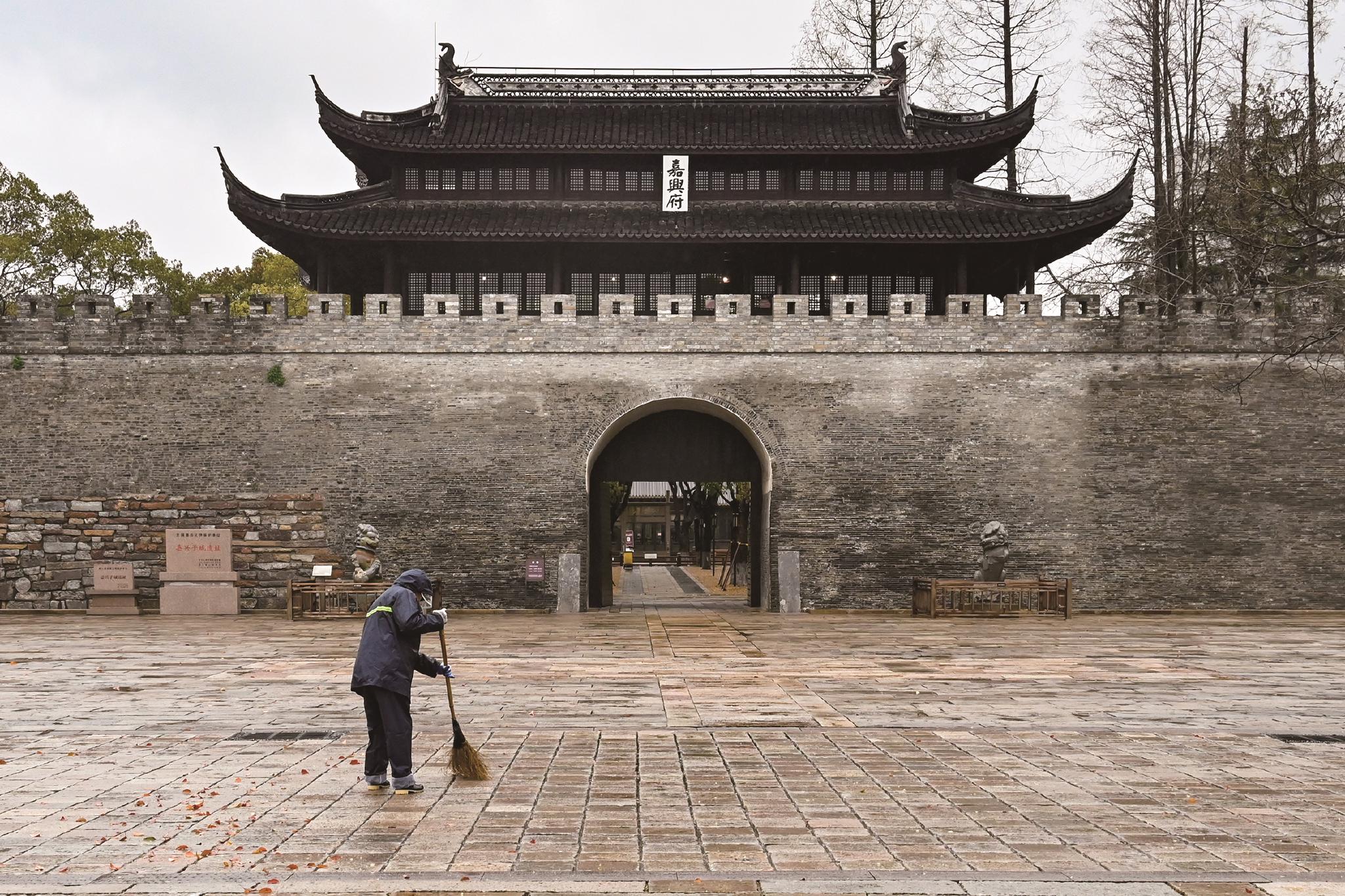 员抓紧时间在雨中清扫落叶,等待市民来子城感受嘉兴的历史文化底蕴