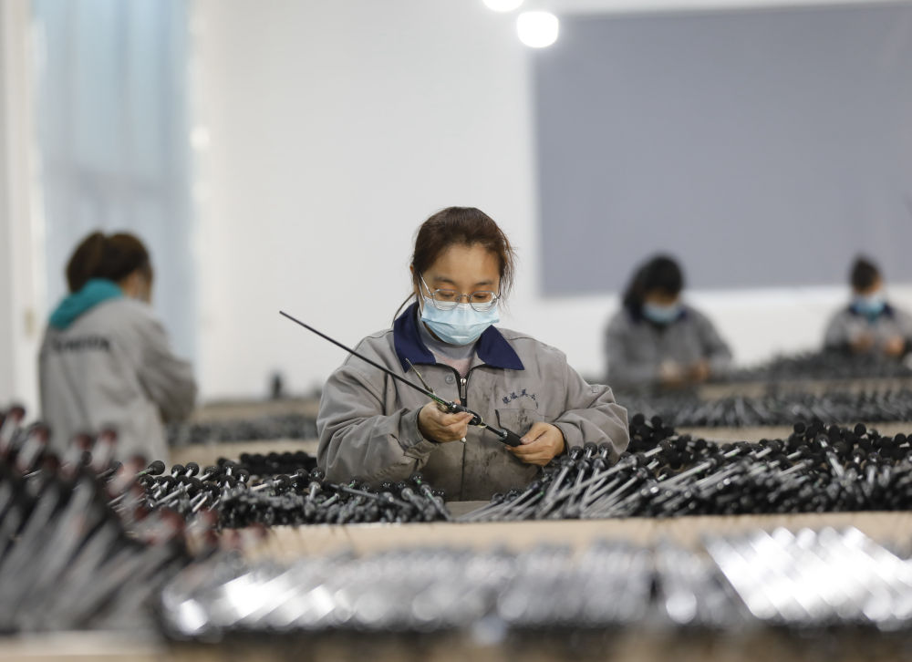 在河北省固安县彭村乡一家渔具企业生产车间,工人们正组装鱼竿.