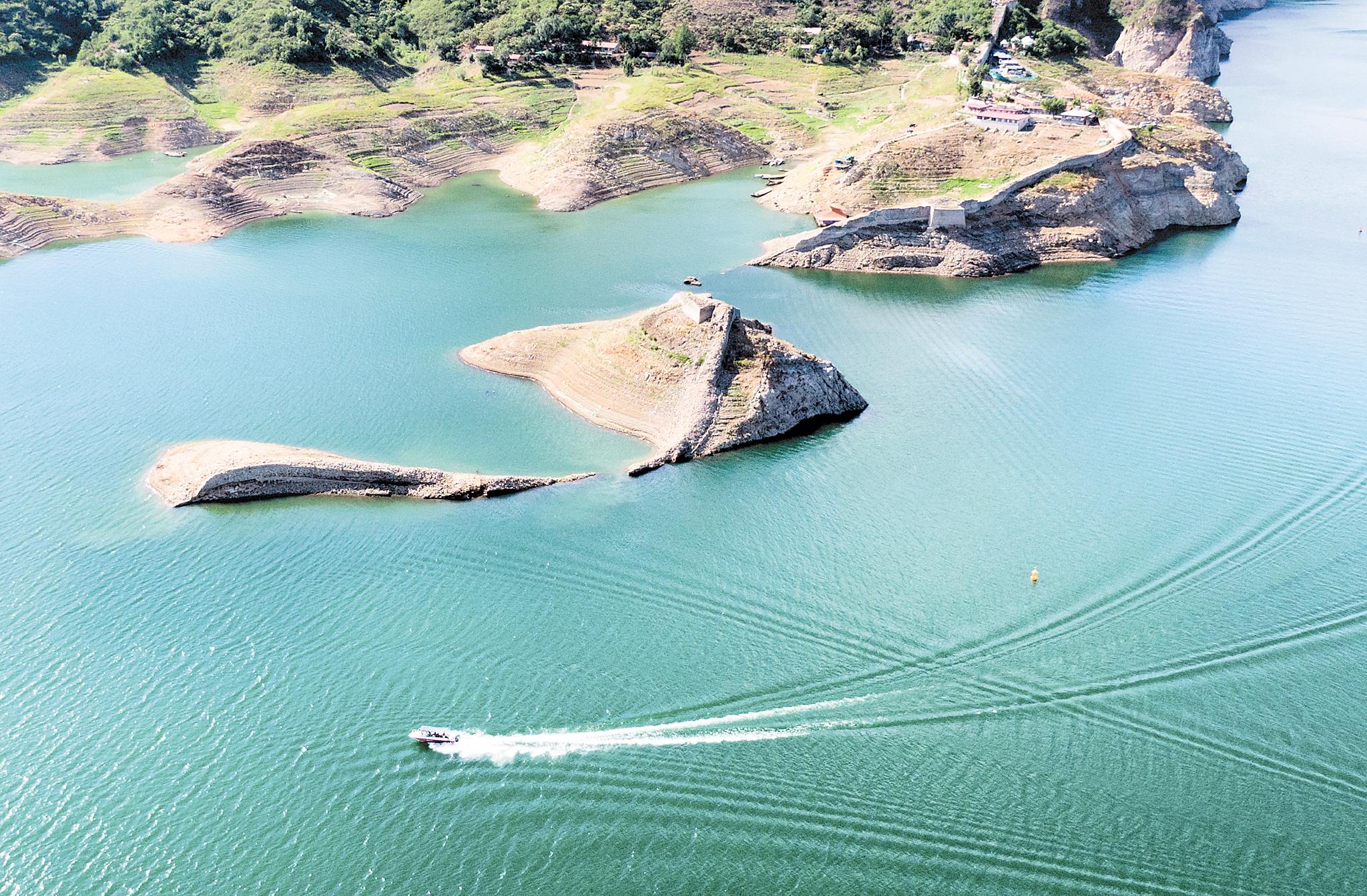 一艘遊船駛過潘家口「水下長城」。河北日報資料片