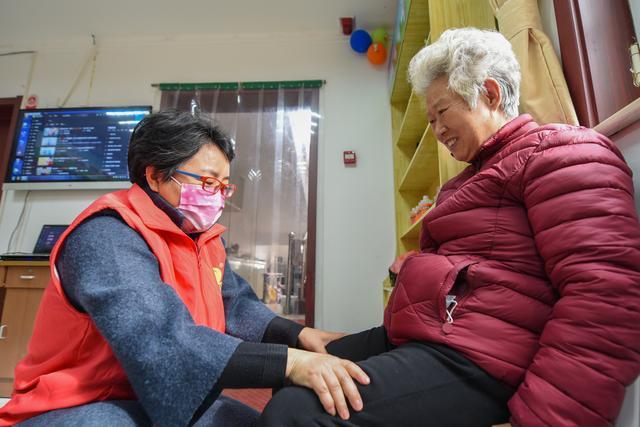 河北省邯郸市邯山区的志愿者正在为老人做腿部按摩.