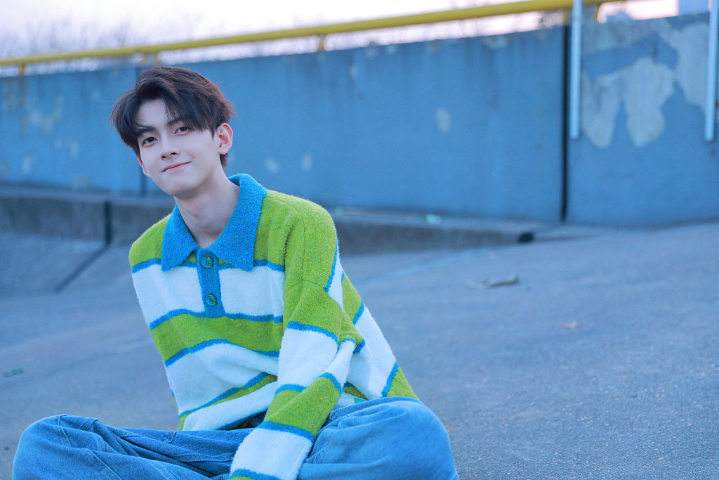 演员陈鹤一户外写真化身白衣少年 眼神干净澄澈沐浴春