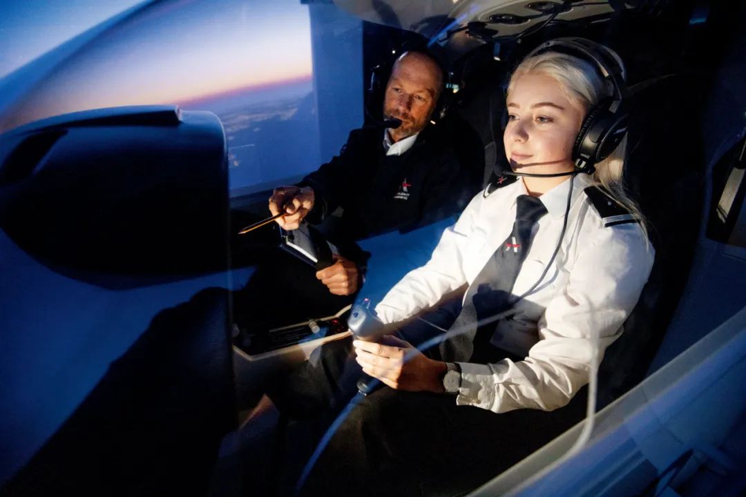 英国苏格兰最大的飞行学校AST航空培训机构，技师带着学员在飞行模拟器中练习。图/视觉中国
