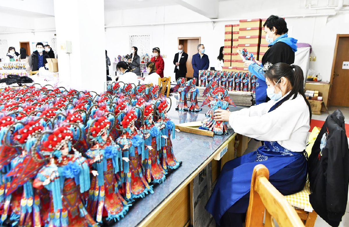 　　唐人坊员工正在将制作完成的唐娃娃打包装盒。（资料图）记者 唐建/摄