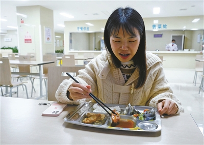由于过了饭点,整个食堂只有她一个人在吃饭.