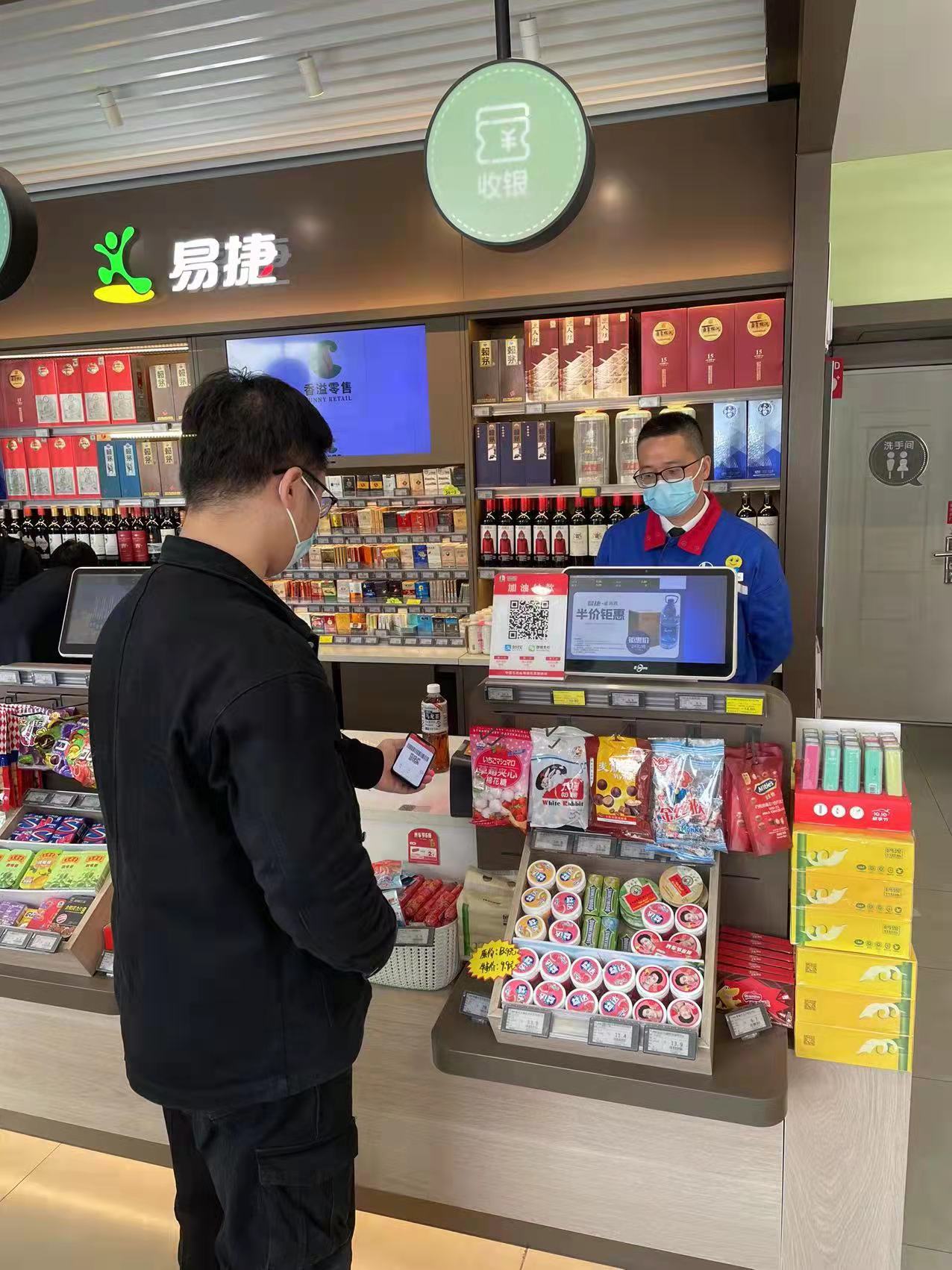 图为消费者正使用数字人民币在易捷便利店进行支付.图片来源:银联商务