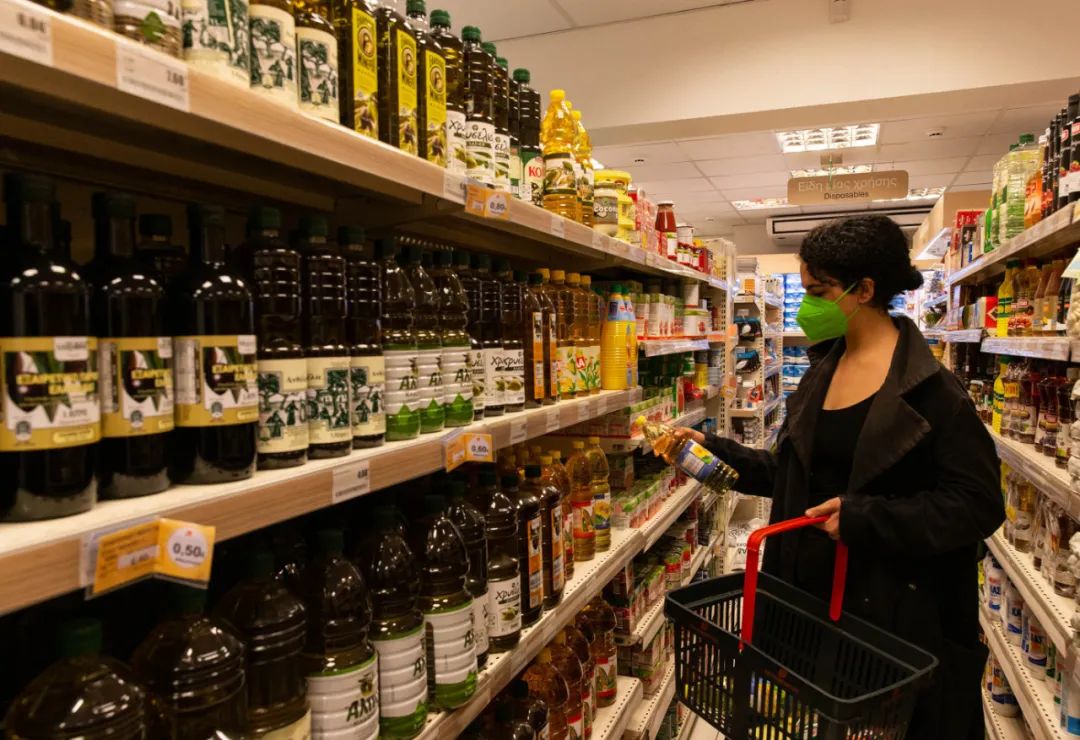 顾客在希腊雅典一家超市内选购食用油.马里奥斯·罗洛斯摄(新华社)