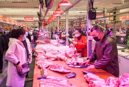 在农贸批发市场，市民在采购猪肉。（资料照片）新华社记者 彭源 摄