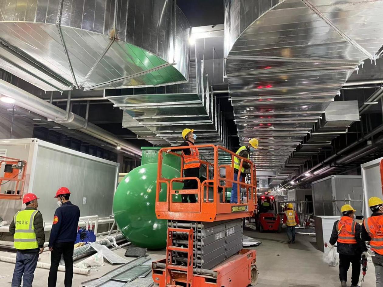 3号馆和4号馆中间过道里,工人们正在安装通风管道.王伟健摄