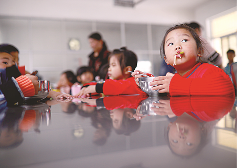 陕西一所幼儿园的小朋友在吃饭。