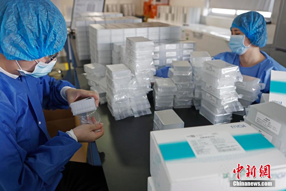 工作人员正在拆解核酸检测的试剂盒。 殷立勤 摄