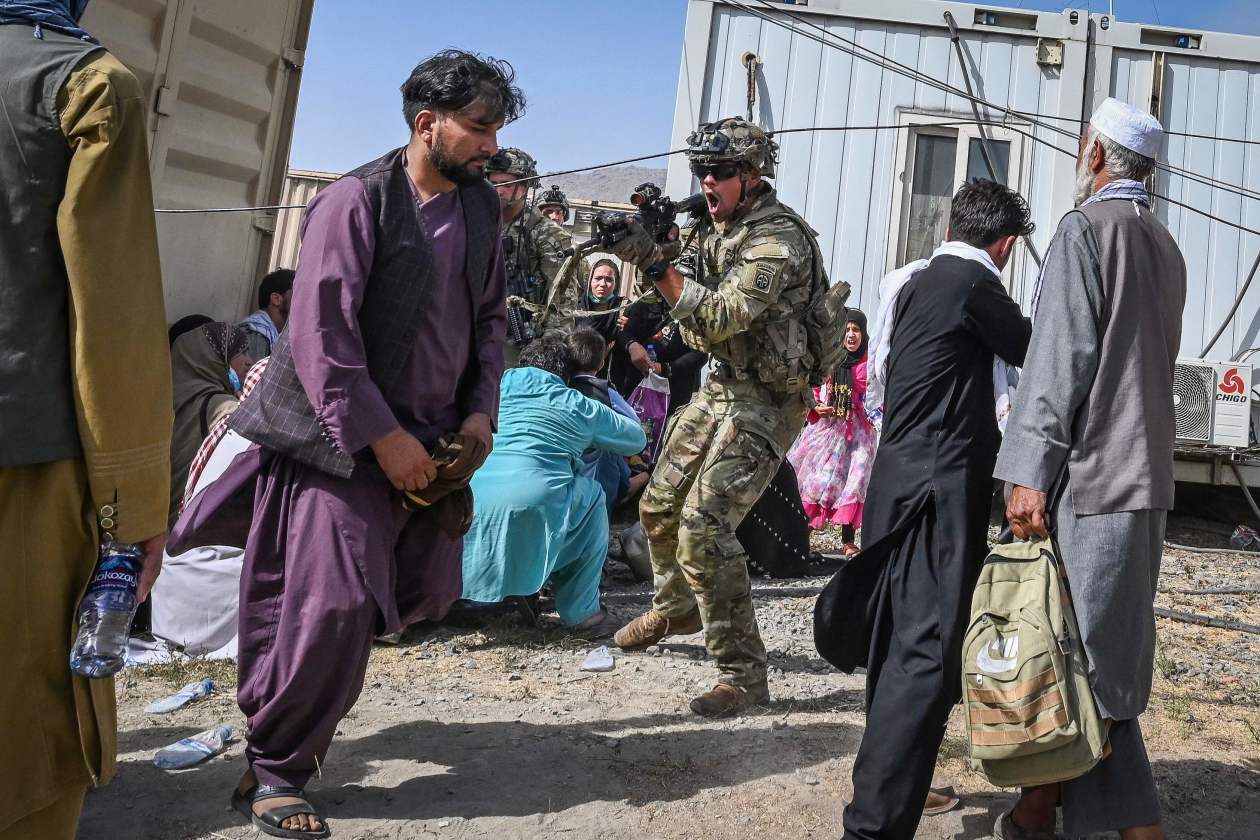  2021年8月16日，一名美军在阿富汗喀布尔机场，用枪指着试图从机场撤离的阿民众。