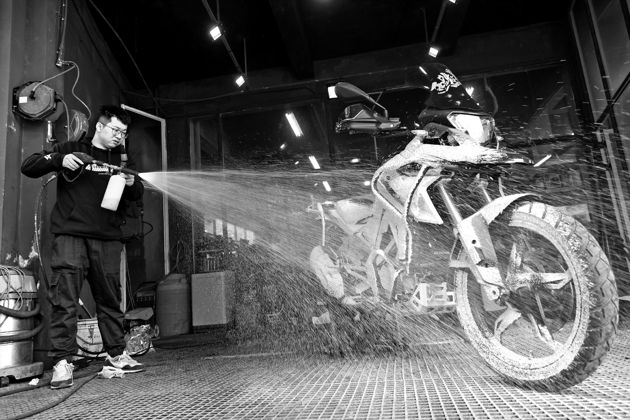 在嘉兴市同济路摩托玩家店内,技师小沈正在清洗一辆宝马摩托车