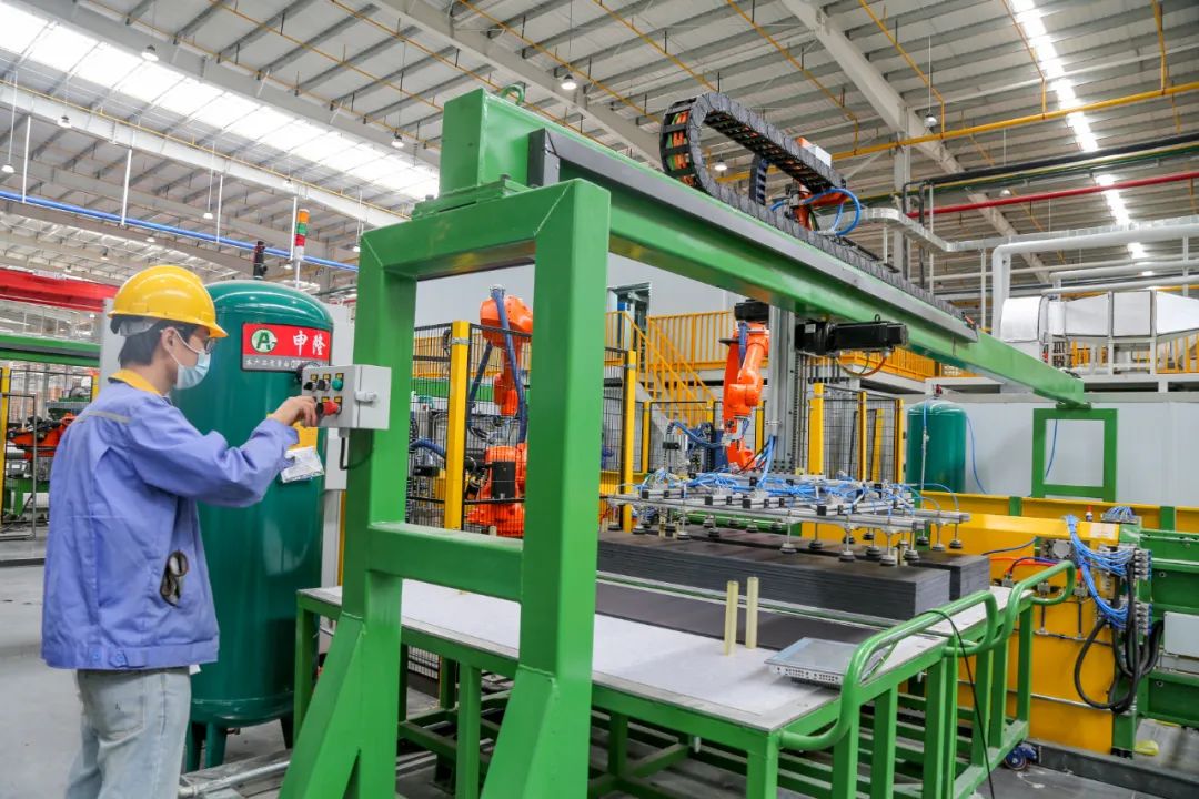 生产线上,白色冰箱内胆通过履带向前移动,固定到指定区域,机器人(11.