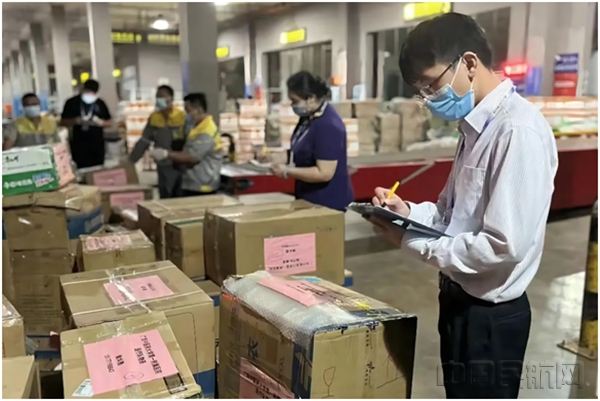南宁机场货站工作人员为不同航班货品粘贴标示贴并清点核对 凌庆/摄