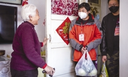 社区书记张莹（中）给刘桂英老人送一些生活必需品。