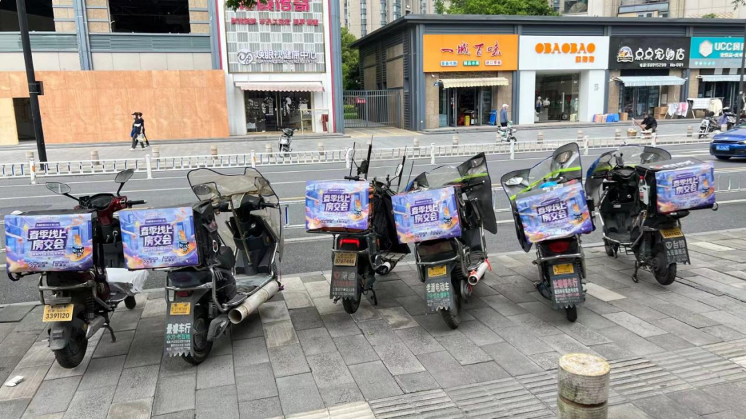 (杭州顺丰同城骑手车厢贴印有本届房交会的宣传海报)