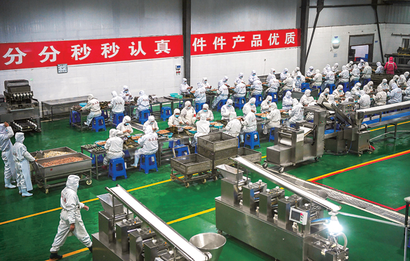位于驻马店市西平县的河南今三麦食品有限公司生产车间内,工人在流水