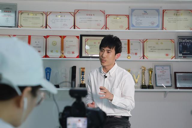 4月21日，史晓刚在公司荣誉墙前向众人介绍AR技术。新京报记者 陈璐 摄