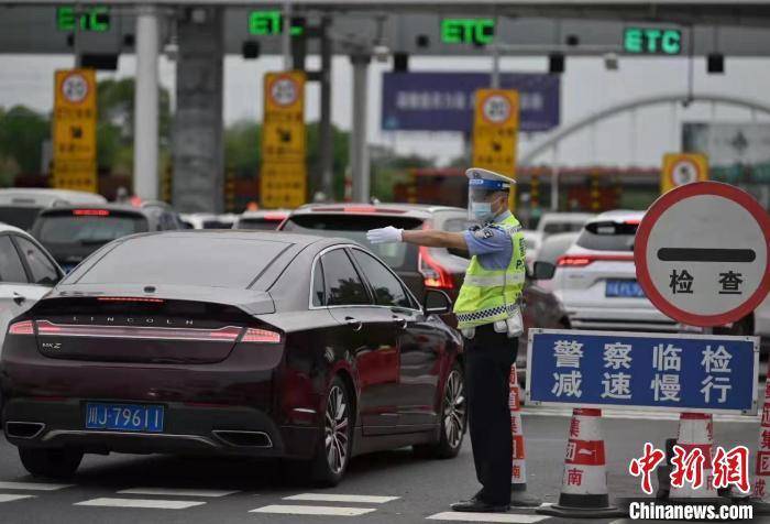 高速公路收费站外车辆排起长队,高速公安正在指挥车辆有序通行.