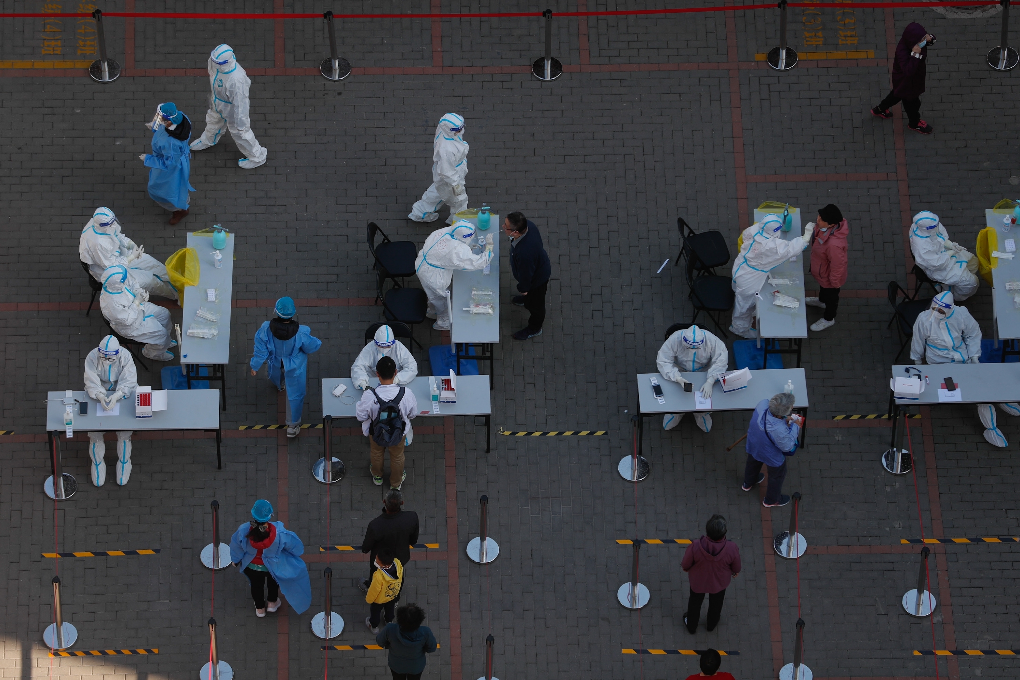 4月30日,苹果园一区休闲广场采样点,医护人员在为社区居民检测核酸.