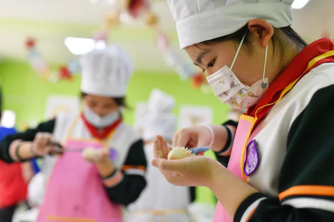 4月28日,山东青岛,小学生们用剪刀学剪传统面食"刺猬"花饽饽.