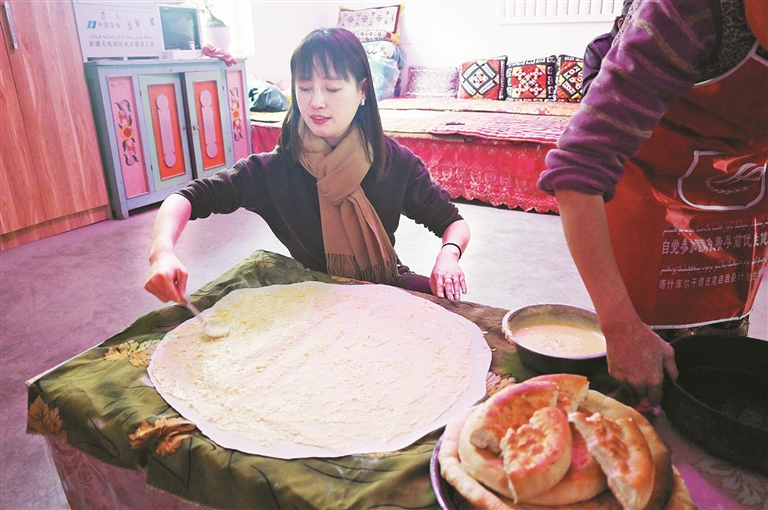 谭婉静在马尔洋乡村民家里学习做面食（资料图片）。