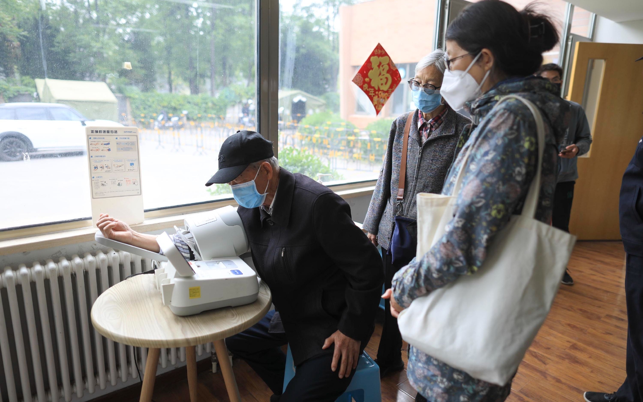 西木学堂疫苗接种点,准备接种新冠疫苗的老人先测量血压.
