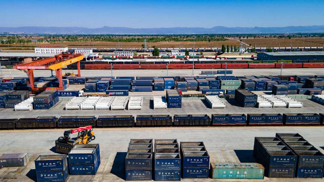 沙良物流园内的机械设备正在装卸集装箱.(通讯员 夏亮摄)