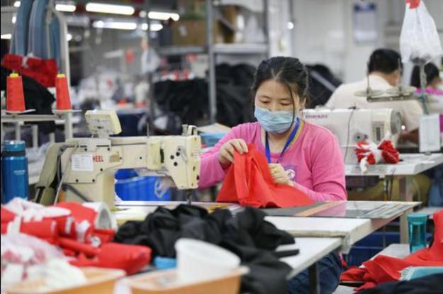 ▲4月27日,福建省福州市仓山区一家制衣企业,工人在出产服装居品。图/新华社