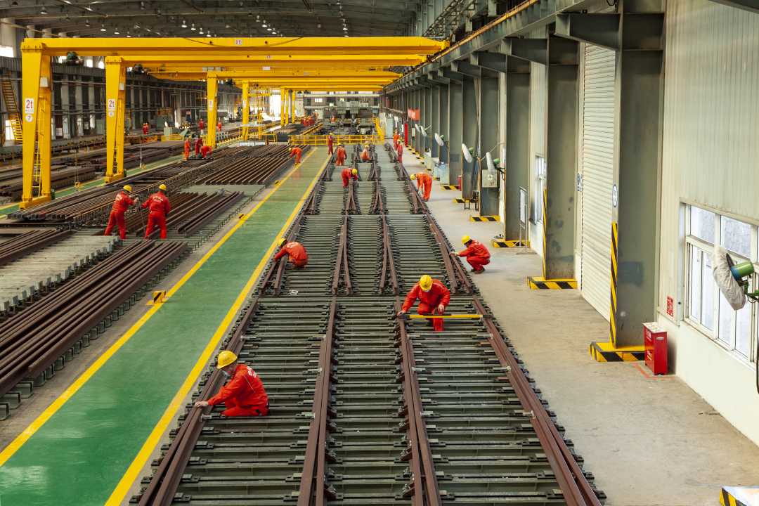 工人正在进行出厂前的逐组试铺调试工作,保障道岔产品的交付质量.