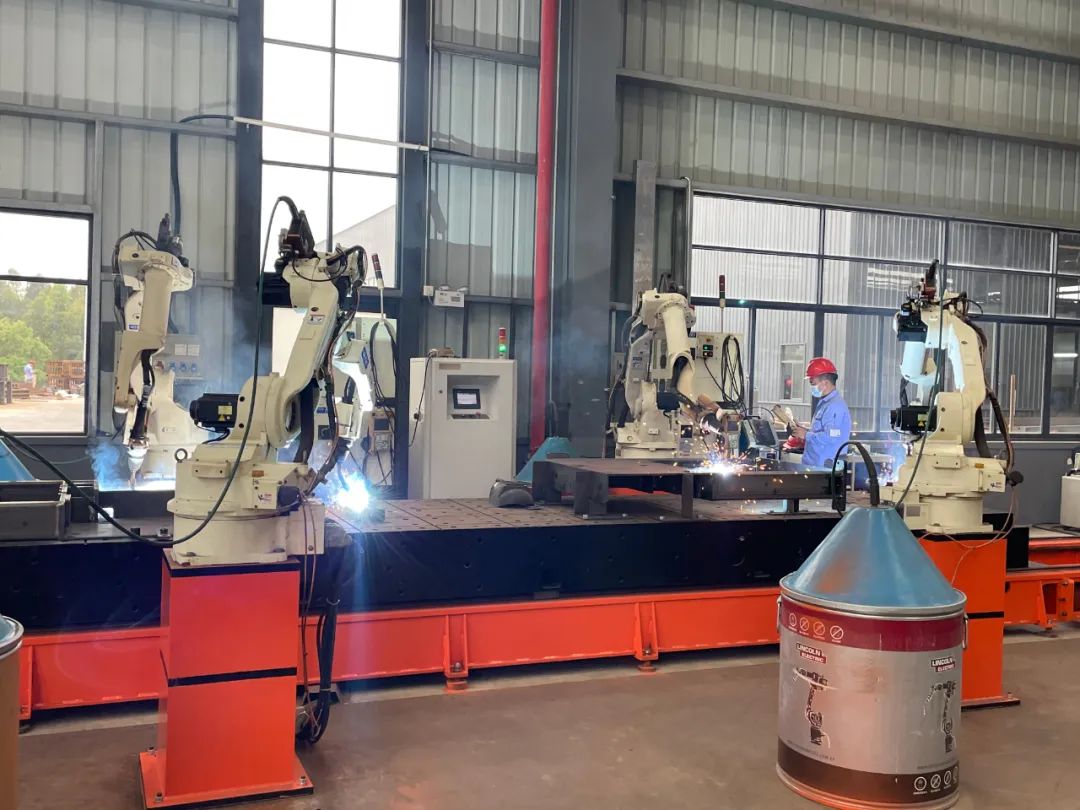 南兴装备(韶关)有限公司生产车间内,工业机器人正在焊接零件.