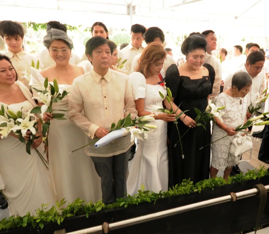 · 2016年，小马科斯和家庭成员在父亲墓前献花。