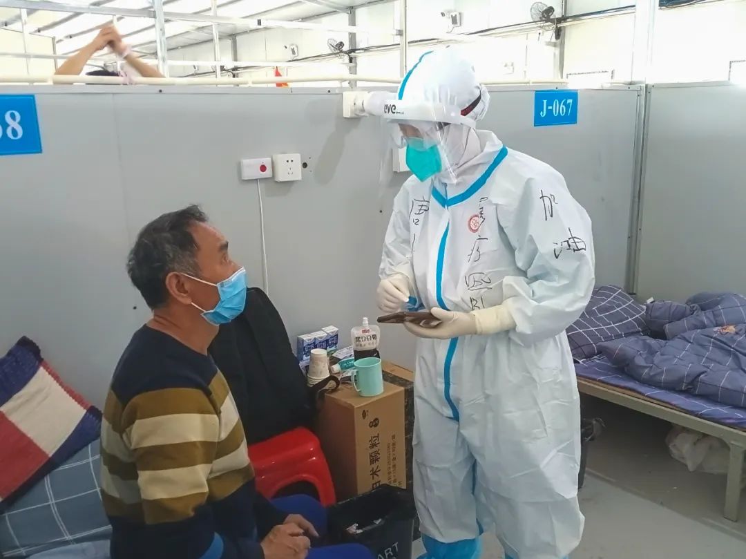 5月1日，  重庆市援沪医疗队医护人员与新入方舱的患者沟通身体情况。