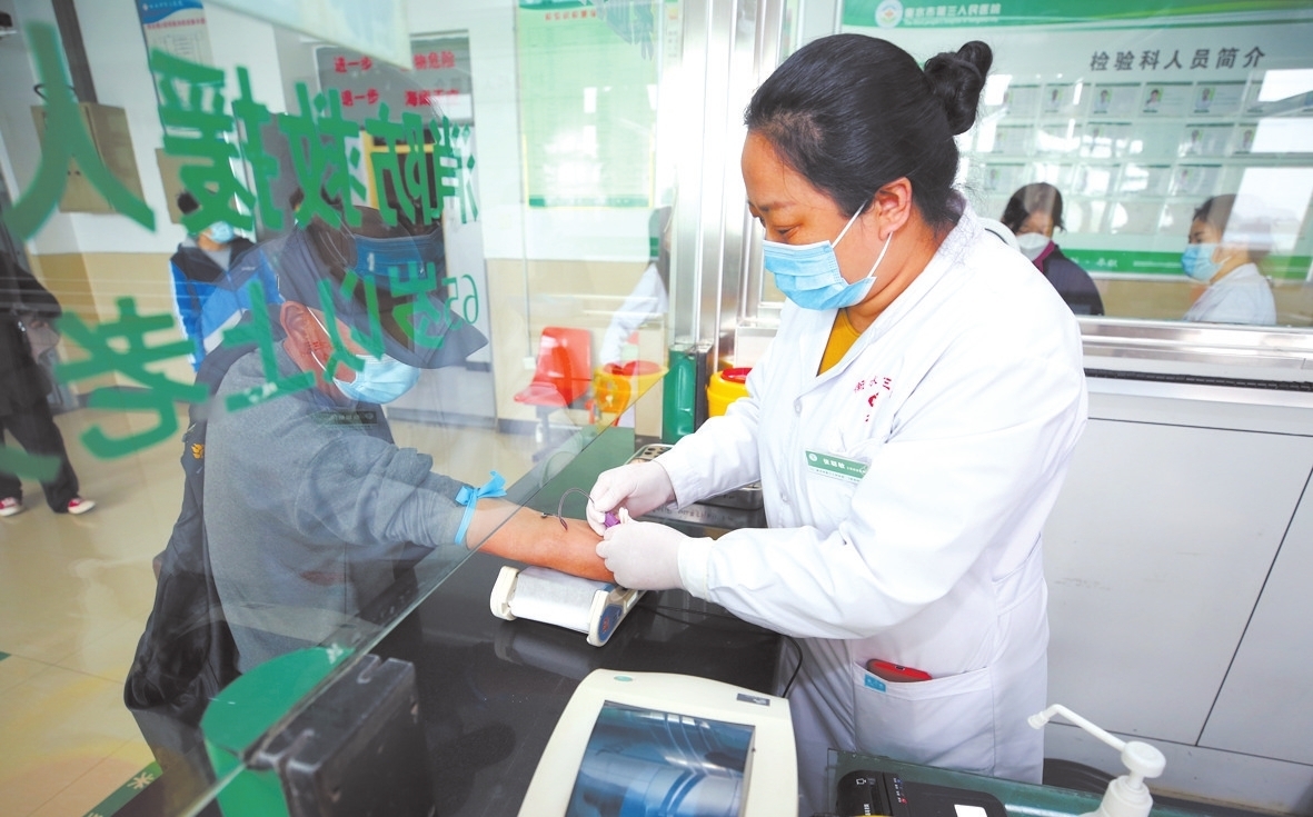 医院各诊疗窗口均已恢复正常,图为患者正在接受采血检查. 陈月振 摄