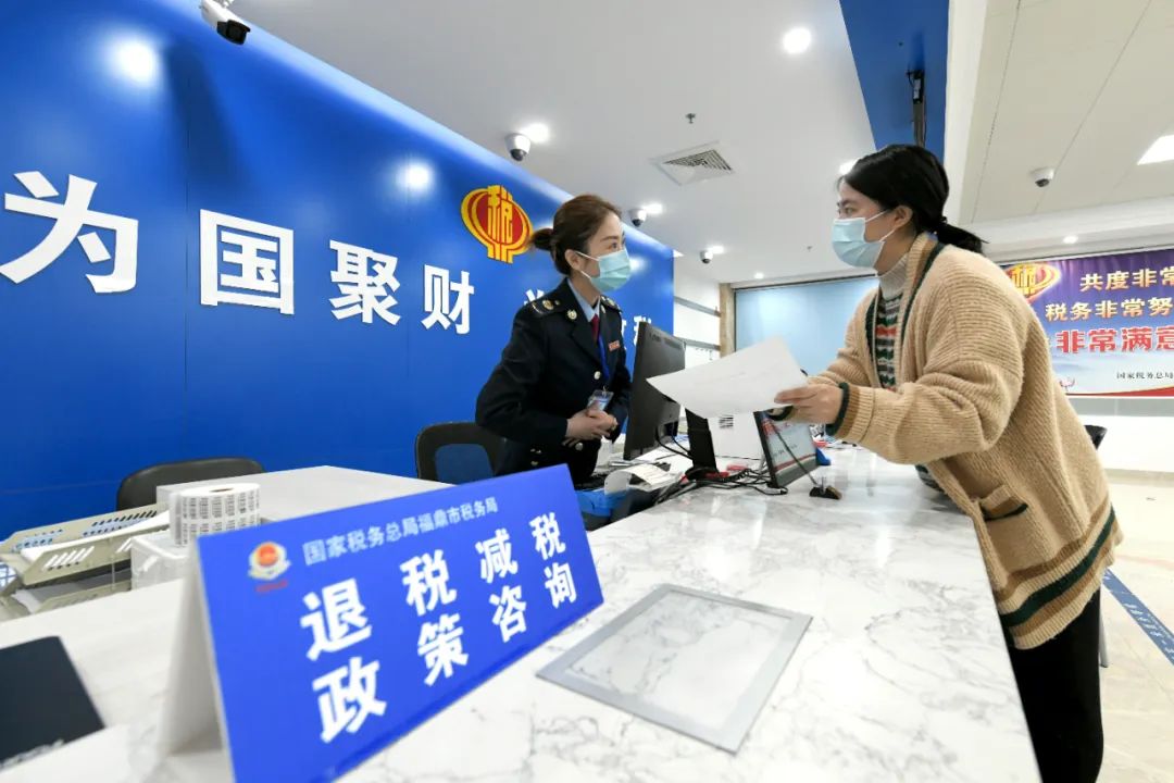 图为国家税务总局福鼎市税务局税务人员为纳税人办理涉税事项.