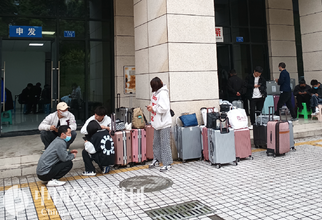 招聘中心门口，堆满了应聘者的行李。