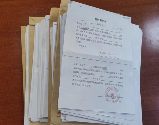 厚厚一摞的社区居民购药委托书.石梦竹 摄