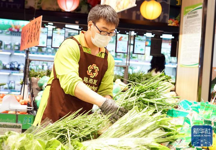 ↑5月13日，在位于北京市海淀区的超市发双榆树店，工作人员摆放蔬菜。新华社记者 任超 摄