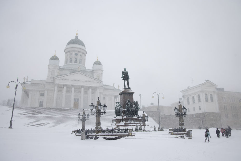 2021年3月9日,行人冒雪在芬兰首都赫尔辛基大教堂前行走.