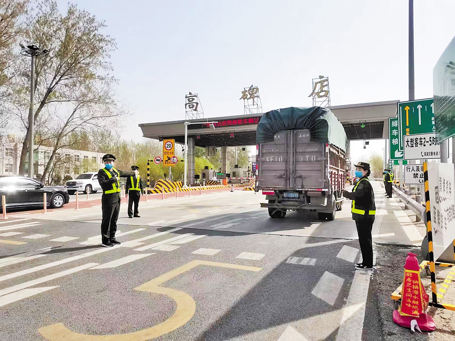 74日前,在京港澳高速公路高碑店收费站,工作人员正在指挥货车快速