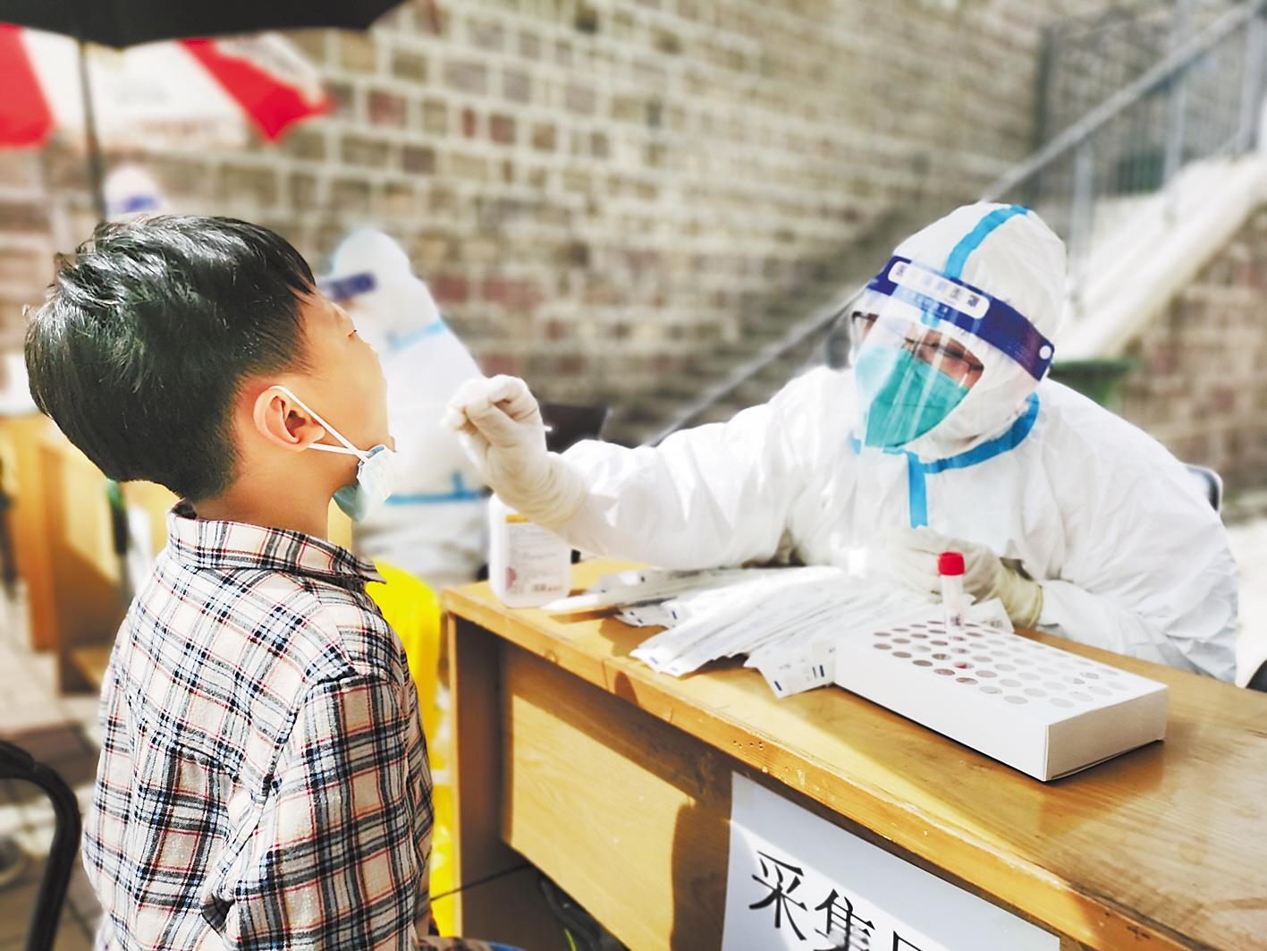 图①:医务人员在小区进行核酸采样. 河北日报记者 陈宝云摄