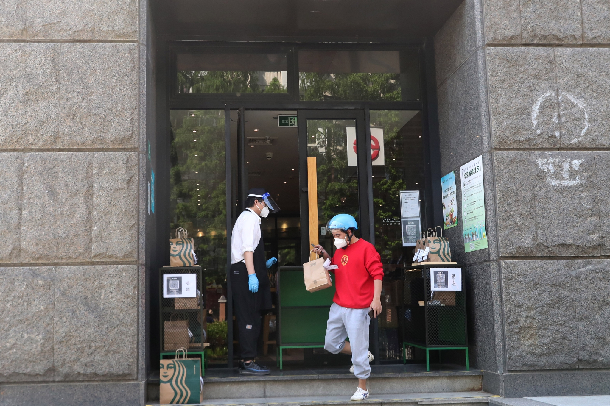5月17日，外卖小哥在位于上海市徐汇区的一家咖啡店外领取网络订单货品准备派送。 图片来源：新华社
