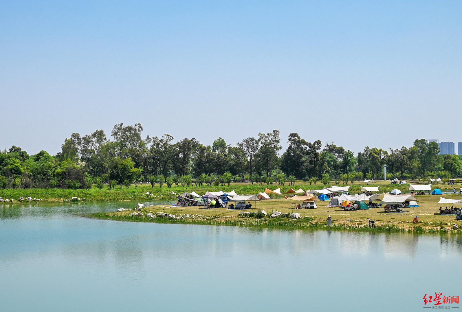 ▲2022年5月4日，市民在成都青龙湖湿地公园湖边搭帐篷 王效 摄