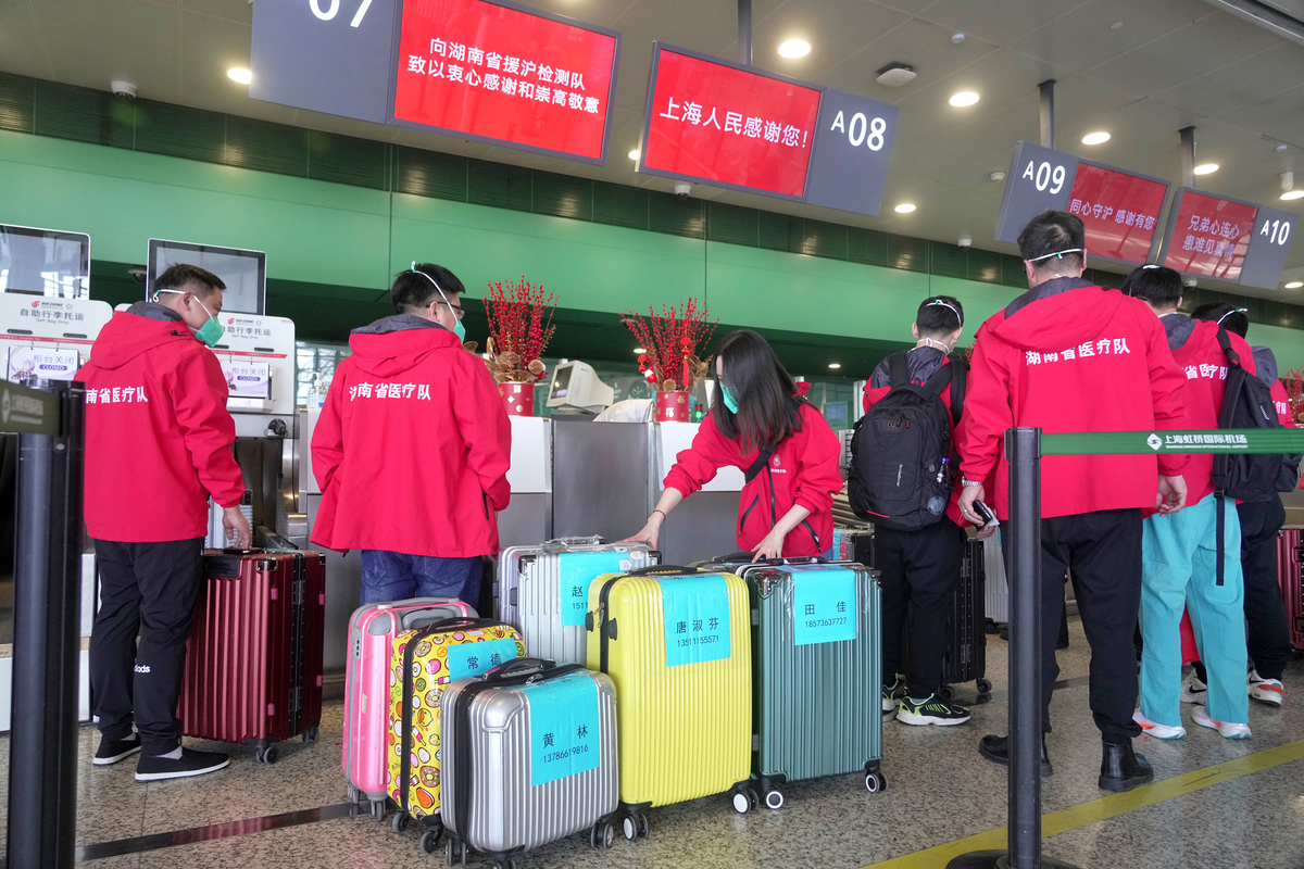 5月18日，湖南省援沪核酸检测队队员办理登机手续。中国日报记者 高尔强 摄