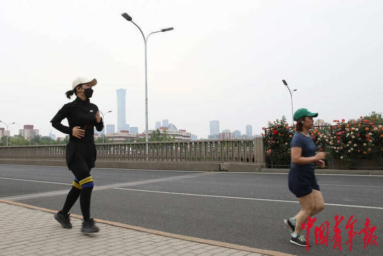 5月19日，北京市东四环辅路边，街头的两名跑步者。中青报·中青网记者 陈剑/ 摄