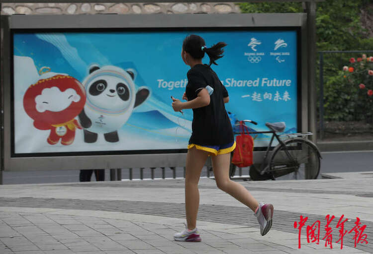 5月19日，北京市东四环辅路边的人行道，一名女孩从一处公交车站前跑过。中青报·中青网记者 陈剑/ 摄