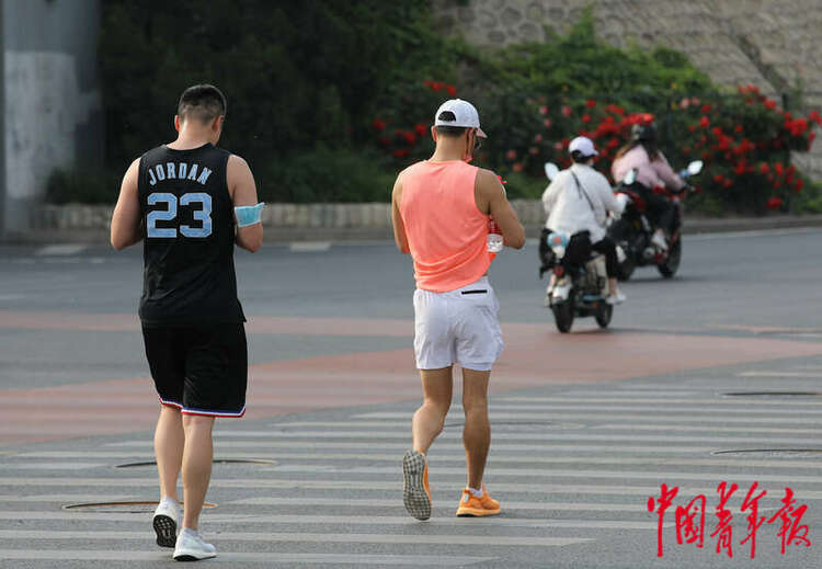 5月19日，北京市东四环，两名跑步的年轻人正在过十字路口。中青报·中青网记者 陈剑/ 摄