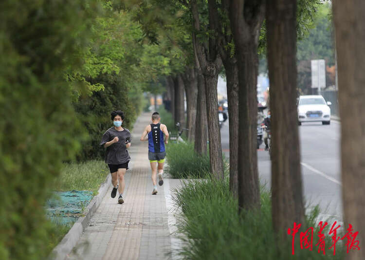 5月19日，北京市东四环辅路边的人行道，两名年轻人正在跑步锻炼身体。中青报·中青网记者 陈剑/ 摄