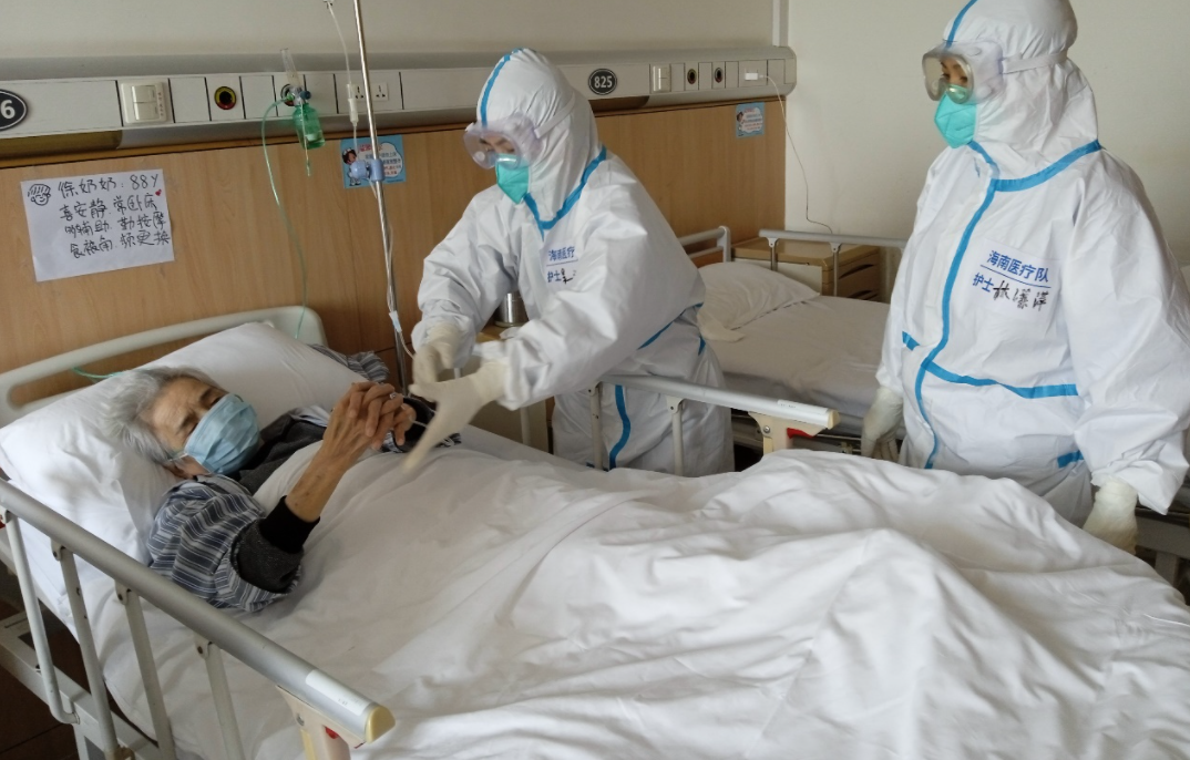 海南医疗队队员吴小丽（中间）和队员林潇萍（右一）正在给88岁的患者做康复训练