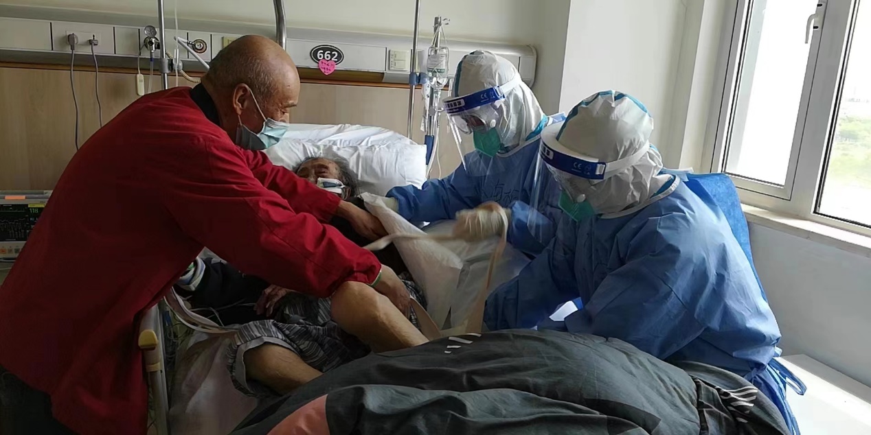 海南医疗队队员在瑞金医院北院病房协助100岁高龄患者翻身